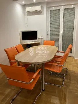 Dining area with a wooden table and orange chairs. - image 8