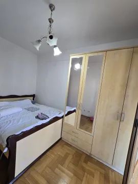 Spavaća soba sa bračnim krevetom i drvenim ormarom sa ogledalom. - image 11