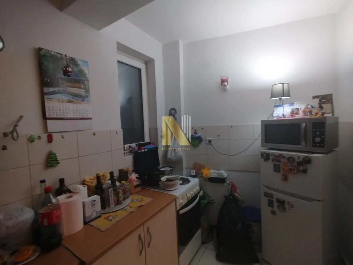 Manja kuhinja sa elementima i kućnim aparatima.