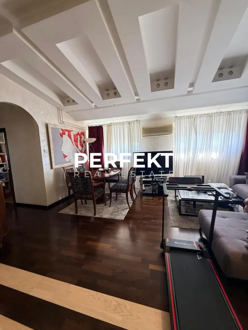 Prostrana dnevna soba sa garniturom, trpezarijom i spuštenim plafonom sa ugradnom rasvetom.