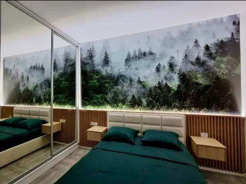 Modern bedroom with a double bed and forest motif wallpaper. - image 4