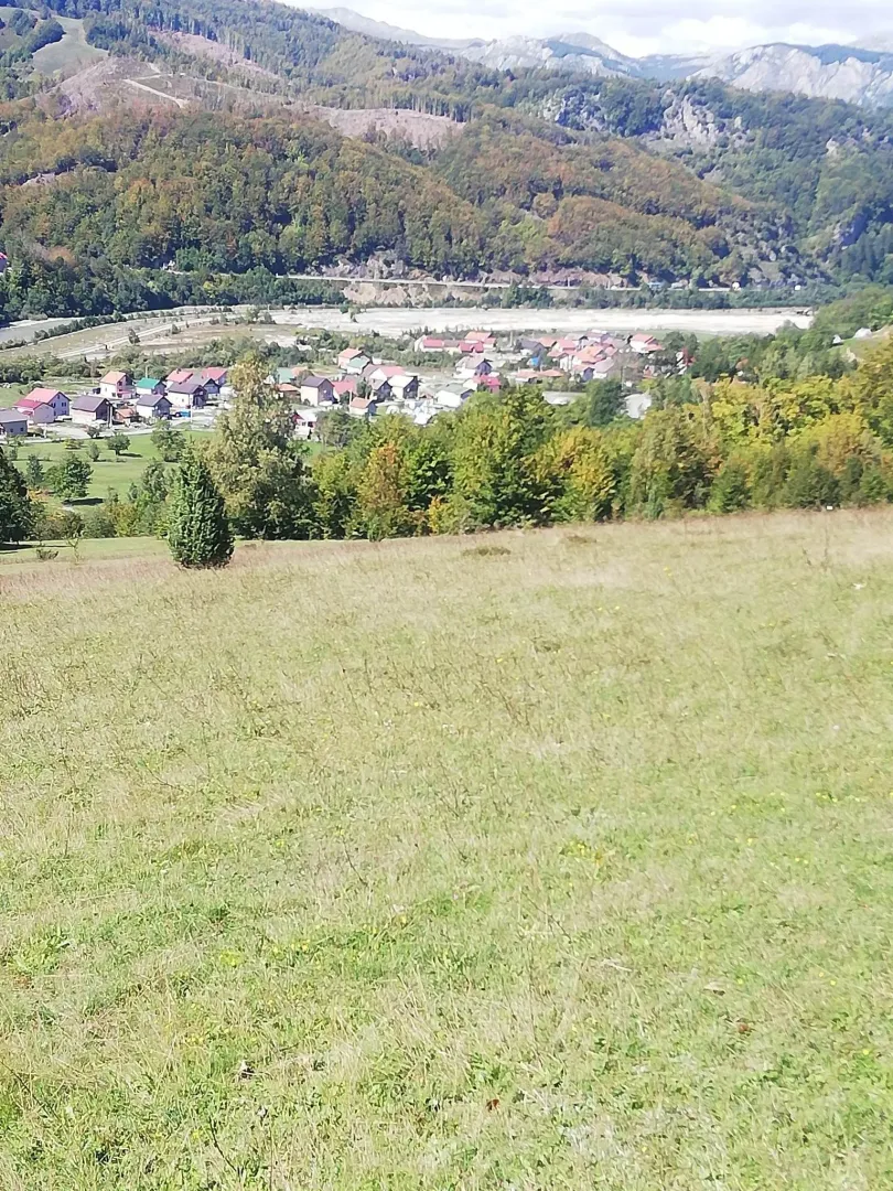Pogled na planinski pejzaž i naselje sa prostranog placa.