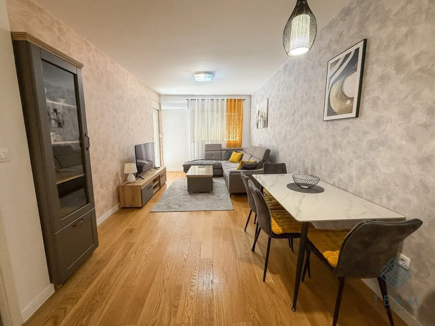 Living room with dining area, sofa set and TV.