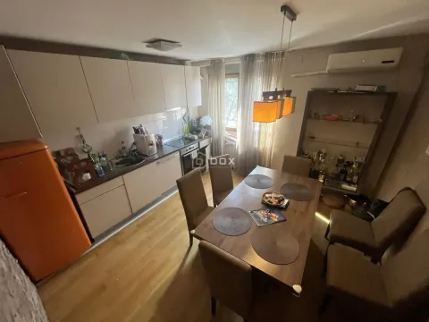 Kuhinja sa trpezarijom opremljena drvenim elementima i stolom za ručavanje. - image 3