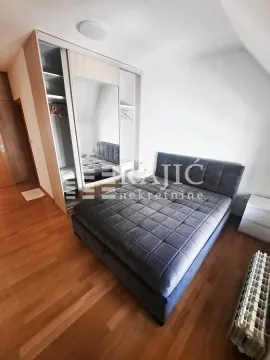 Furnished bedroom with a large double bed and built-in wardrobe. - image 16