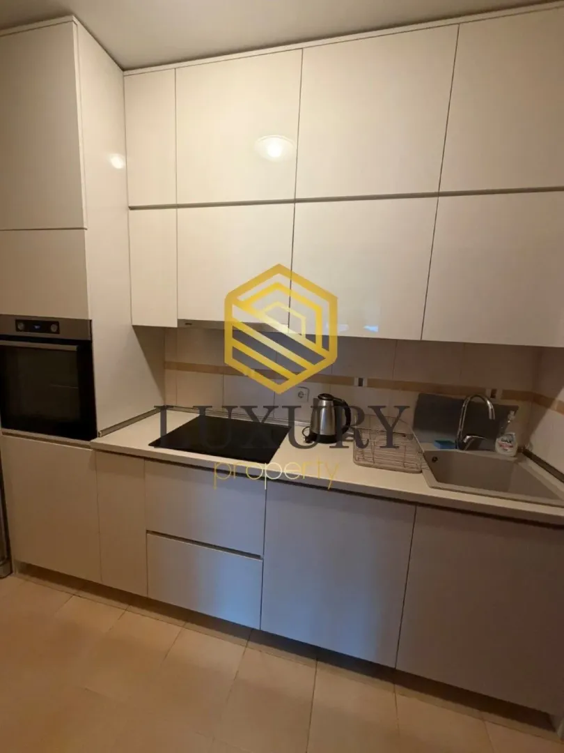 Moderna bijela kuhinja sa ugradnim uređajima.