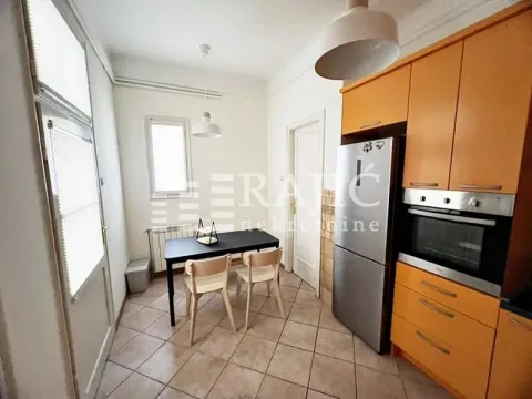 Kitchen with a dining table and orange cabinets. - image 13