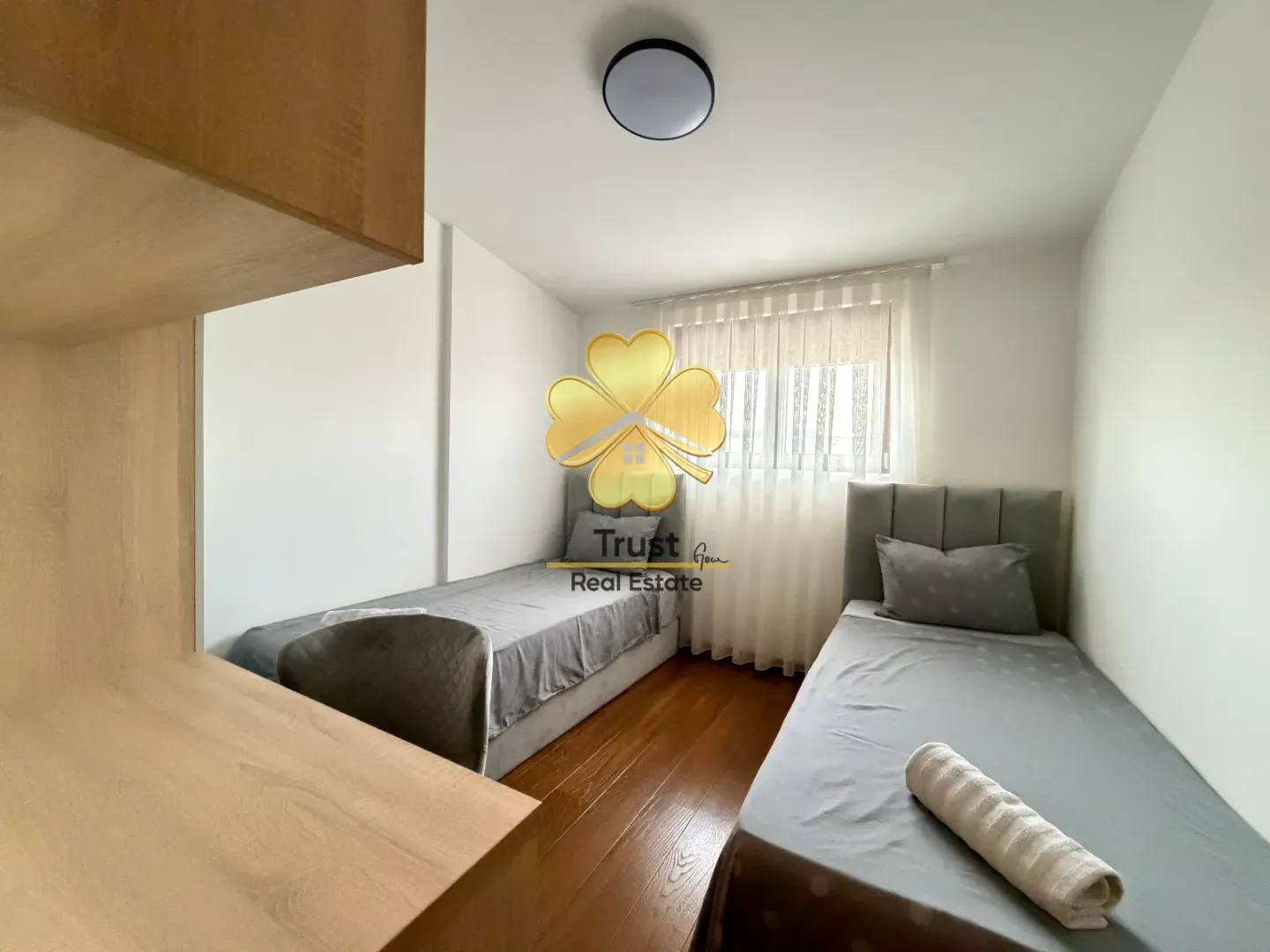 Bedroom with two single beds and a desk.