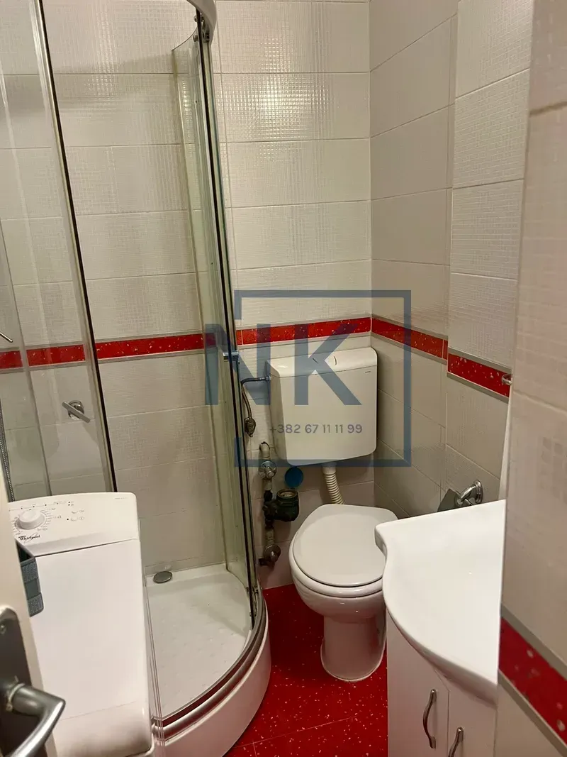 Bathroom equipped with a shower cabin, toilet, sink, and washing machine.