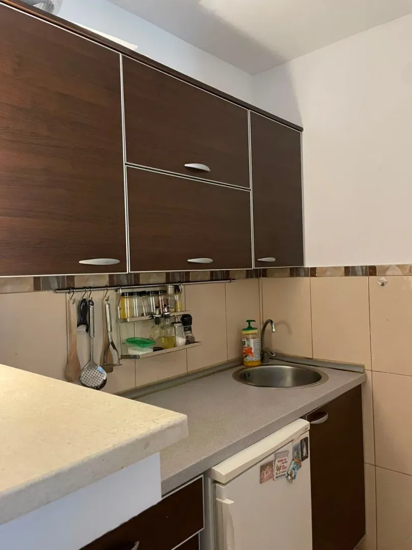 Small kitchen with dark wooden cabinets and a sink.