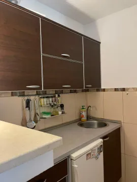 Small kitchen with dark wooden cabinets and a sink. - image 8