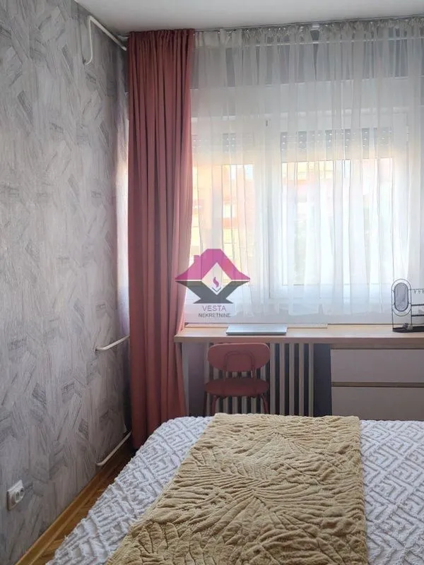 Small bedroom with a bed and a desk under the window.