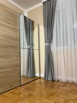 Pogled na dio spavaće sobe sa velikim plakarom sa ogledalom i prozorom sa zavjesama. - image 10