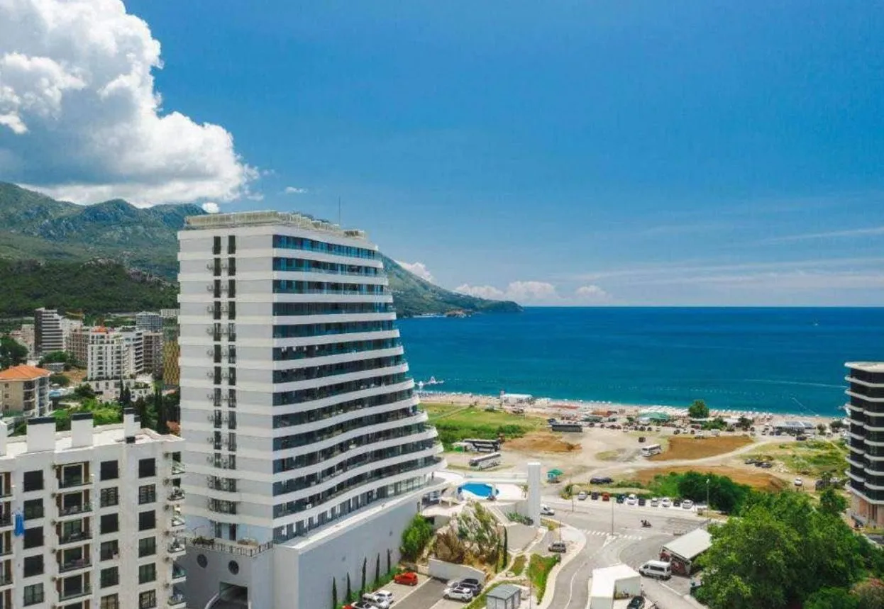 Pogled iz vazduha na modernu višespratnicu u blizini obale mora i plaže.
