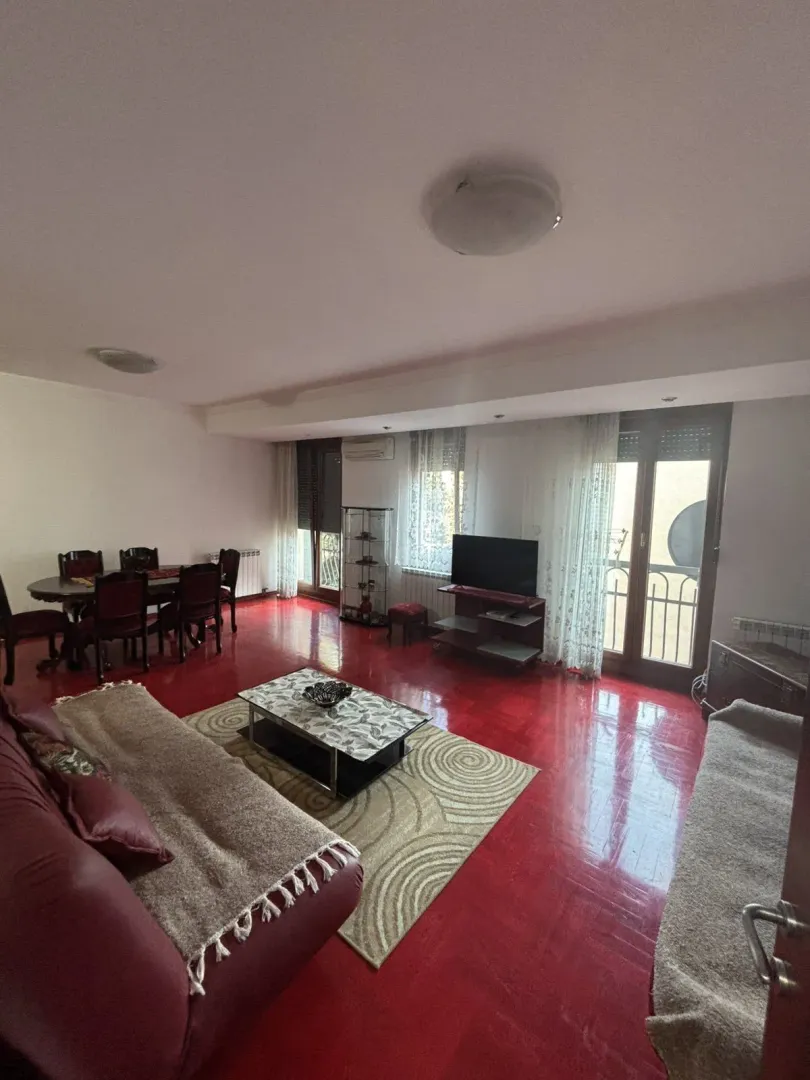 Bright living room with red floors and a dining area.
