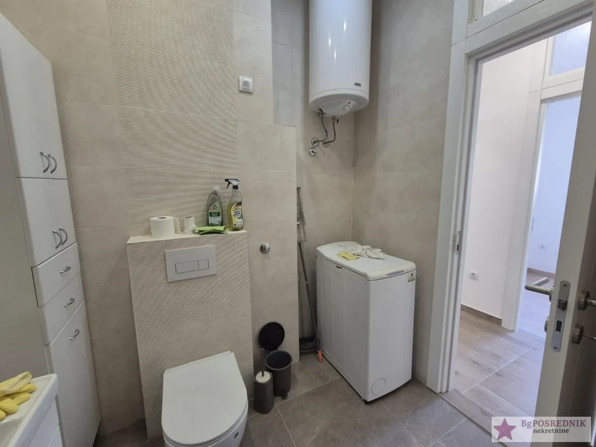 Bathroom equipped with a toilet, washing machine, and water heater.
