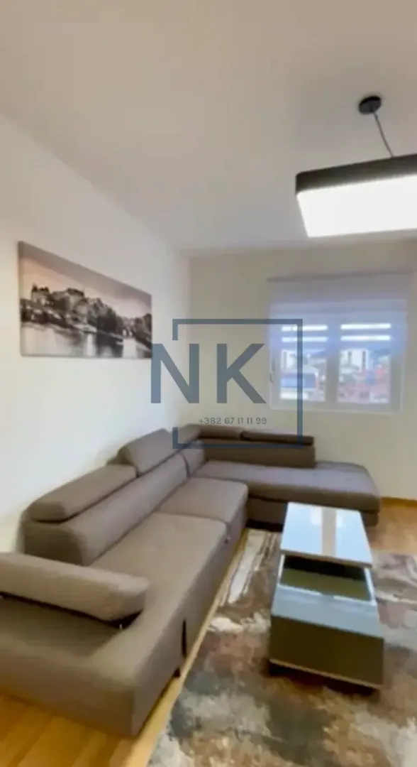 Living room with a sectional sofa, coffee table, and window.