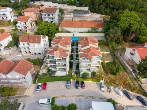 Pogled iz vazduha na stambene zgrade sa bazenom i teniskim terenom. - image 4