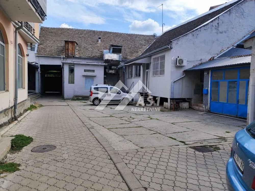 View of the courtyard with a parked car in front of the ground floor building.