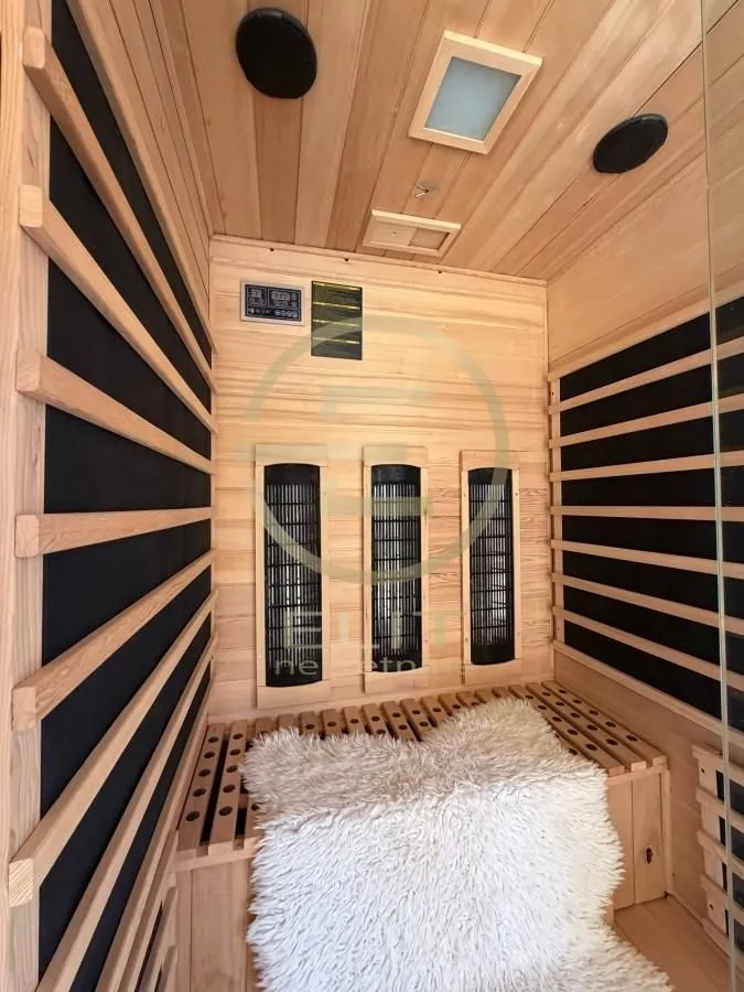 Privatna drvena sauna sa klupom i ugrađenim grejačima.