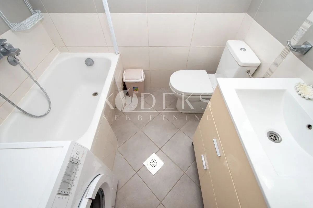 Kompaktno opremljeno kupatilo sa kadom, umivaonikom i WC šoljom.