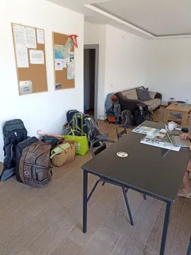 Dnevni boravak sa stolom, kaučem i prtljagom na podu. - image 11
