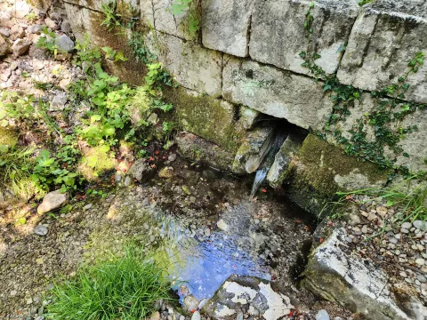 Dvorište sa kamenim zidom i malim izvorom vode. - image 11