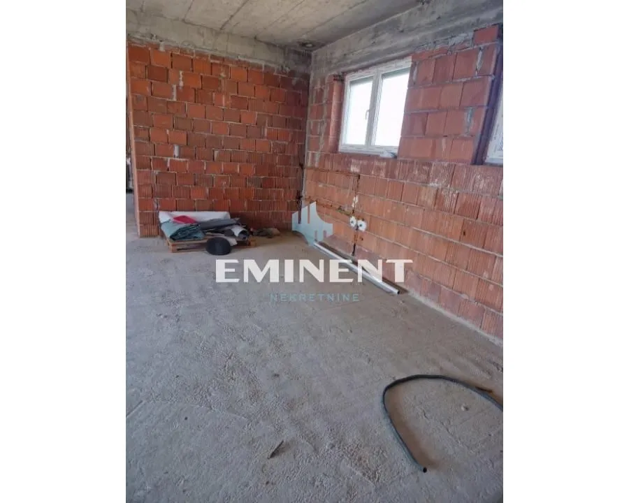 Unfinished room under construction with brick walls and a window.
