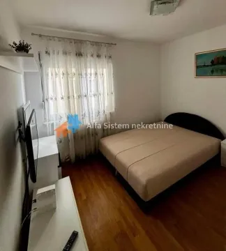 Nameštena spavaća soba sa bračnim krevetom, prozorom i TV-om. - image 8