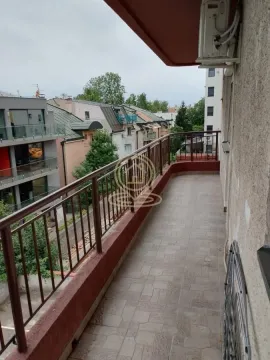 Dugačak popločani balkon sa metalnom ogradom i pogledom na naselje. - image 5