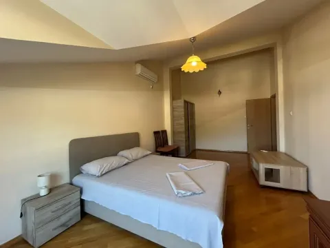 Prostrana spavaća soba sa bračnim krevetom, noćnim stočićem i plakarom. - image 6