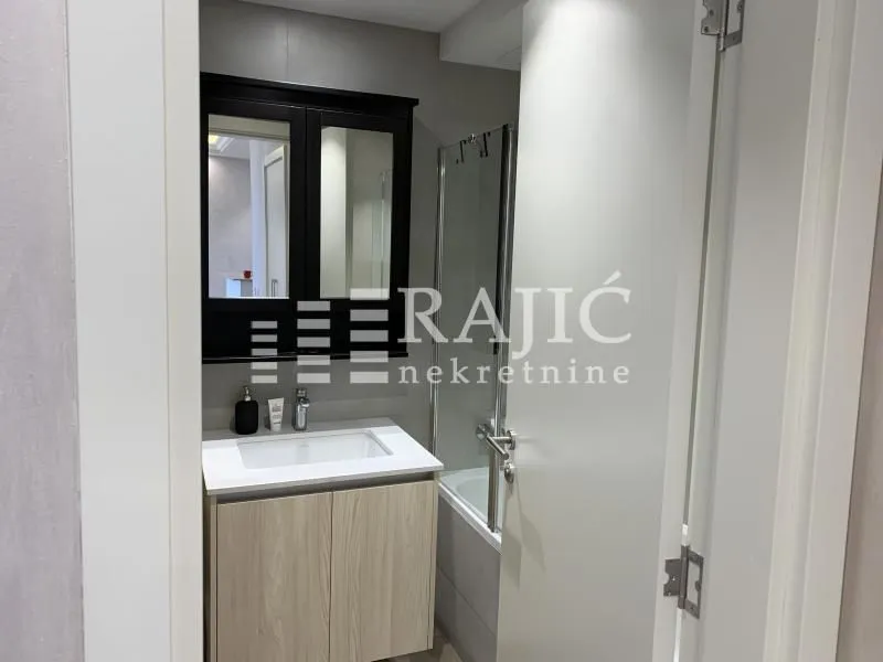 View of a modern bathroom with a vanity and mirror.