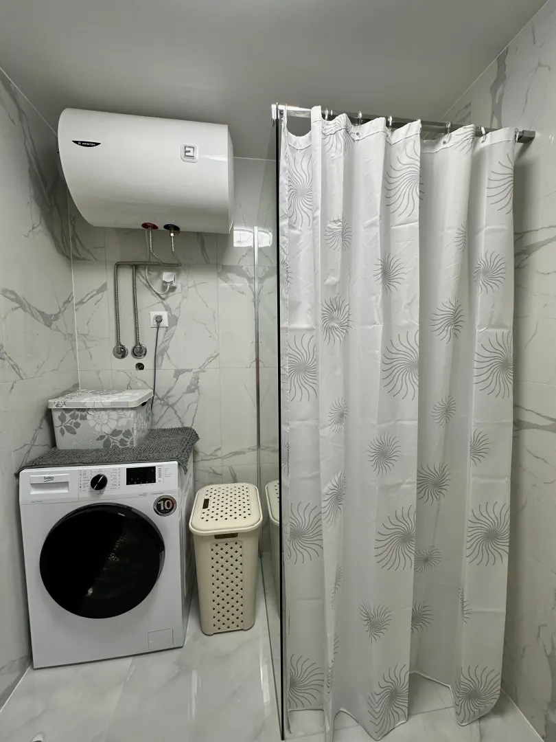 Kupatilo sa tuš kabinom, veš mašinom i bojlerom.