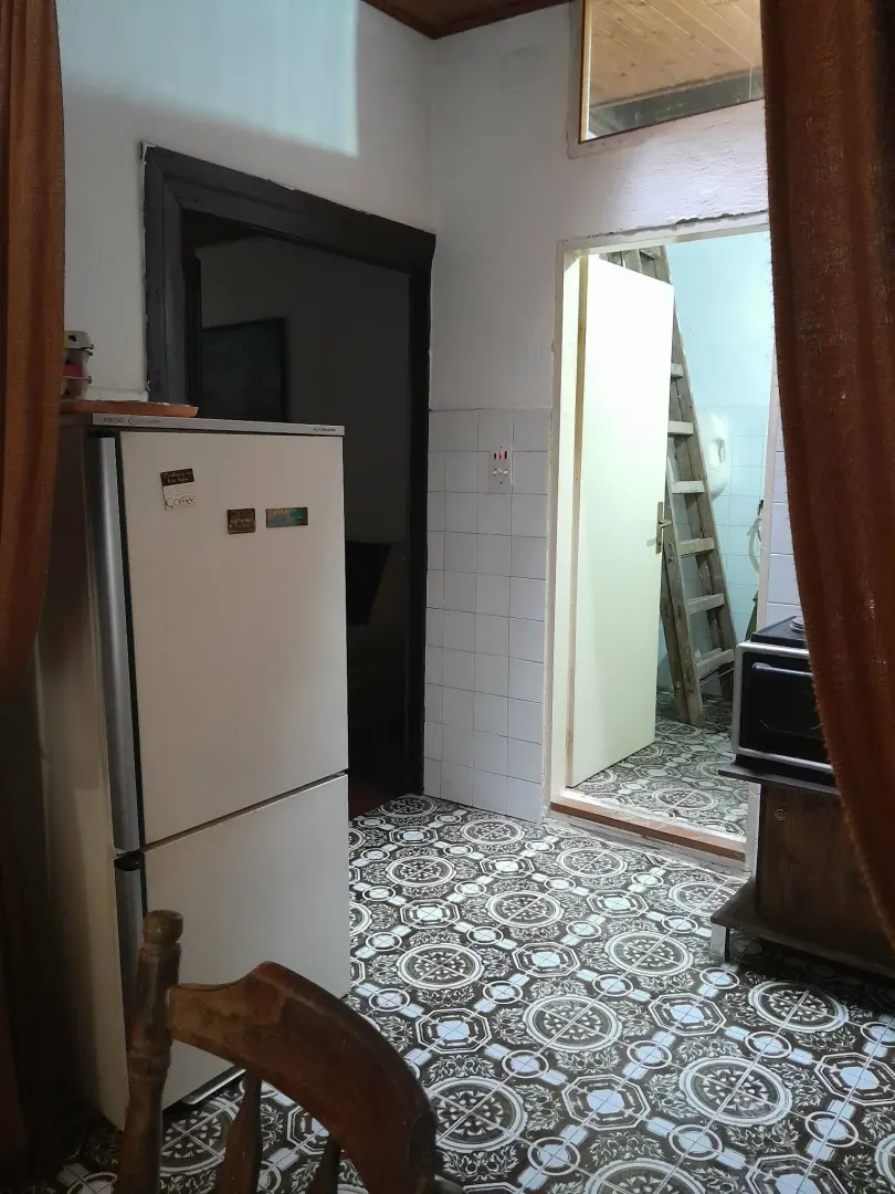 Manja kuhinja sa frižiderom i ukrasnim pločicama na podu.