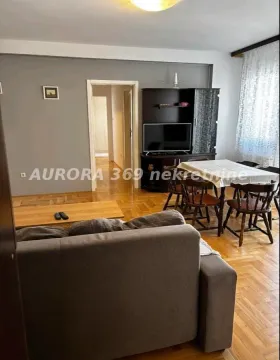 Dnevna soba sa garniturom, trpezarijskim stolom i parketom na podu. - image 2