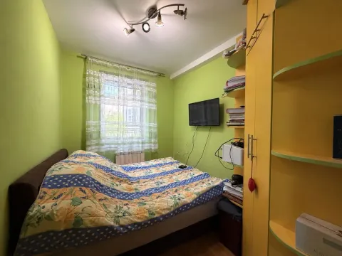 Manja spavaća soba sa krevetom, prozorom i žutim ormarom. - image 9