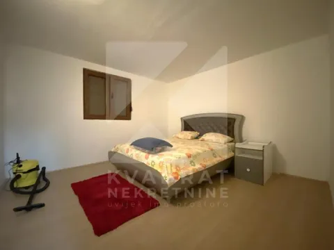 Spavaća soba sa bračnim krevetom, noćnim ormarićem i prozorom. - image 11