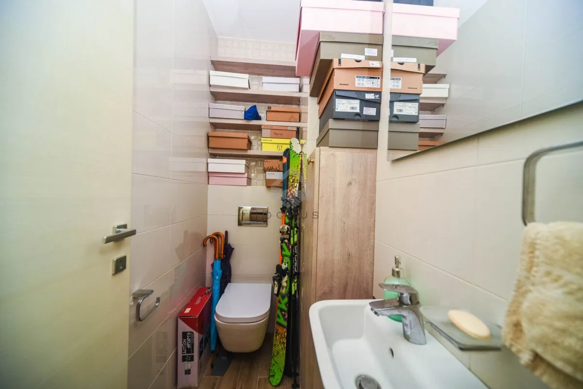 Bathroom equipped with a sink, toilet, and storage shelves.