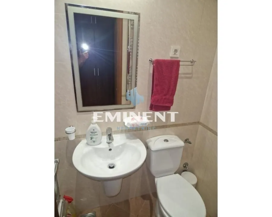Smaller bathroom with a washbasin, mirror, and toilet bowl.