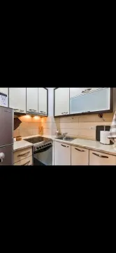 Smaller equipped kitchen with countertops and appliances. - image 2