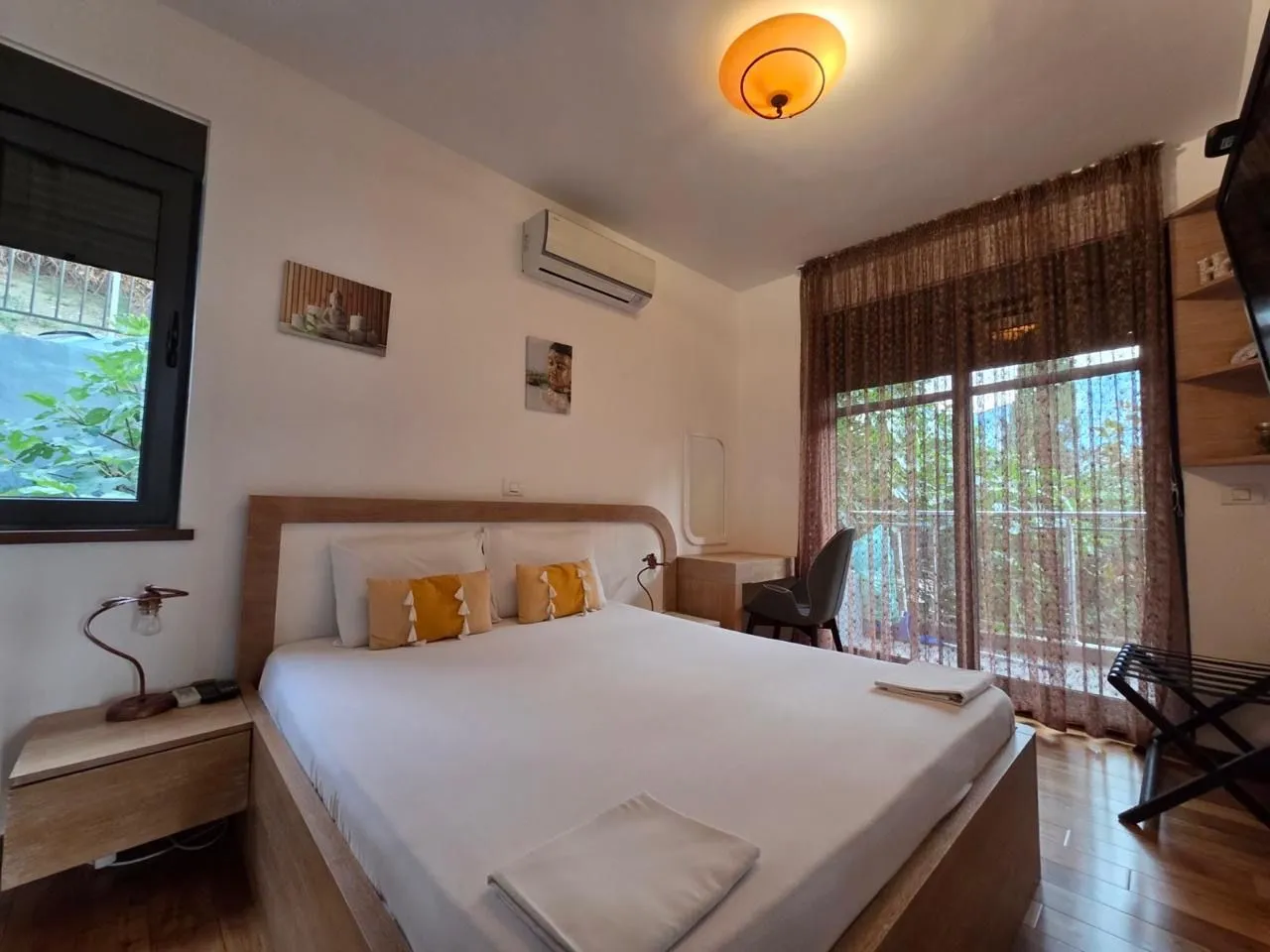 Furnished bedroom with a double bed, desk, and terrace access.