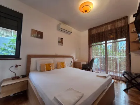 Furnished bedroom with a double bed, desk, and terrace access. - image 12