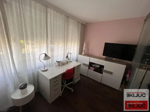Radni sto sa lampom i televizorom pored prozora u sobi sa roze zidom. - image 13