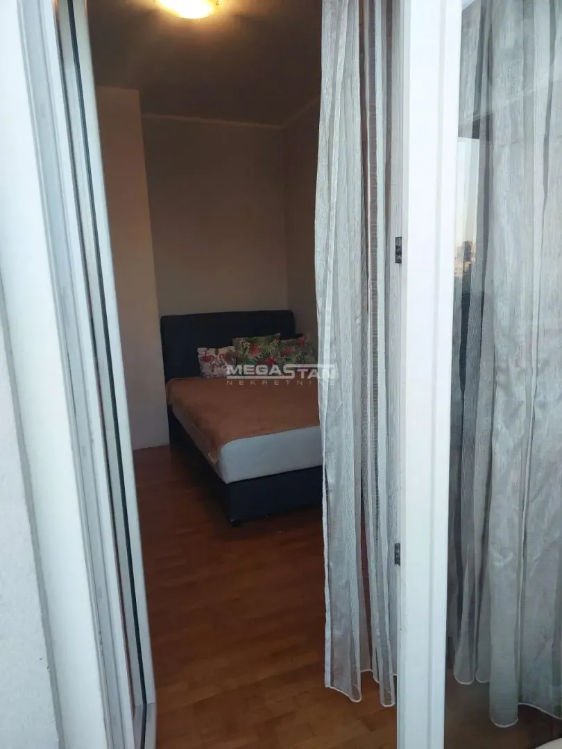View from the passageway into a furnished bedroom with a double bed.