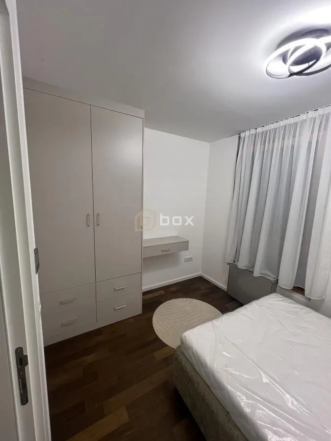 Furnished bedroom with a bed, fitted wardrobe, and wooden flooring.