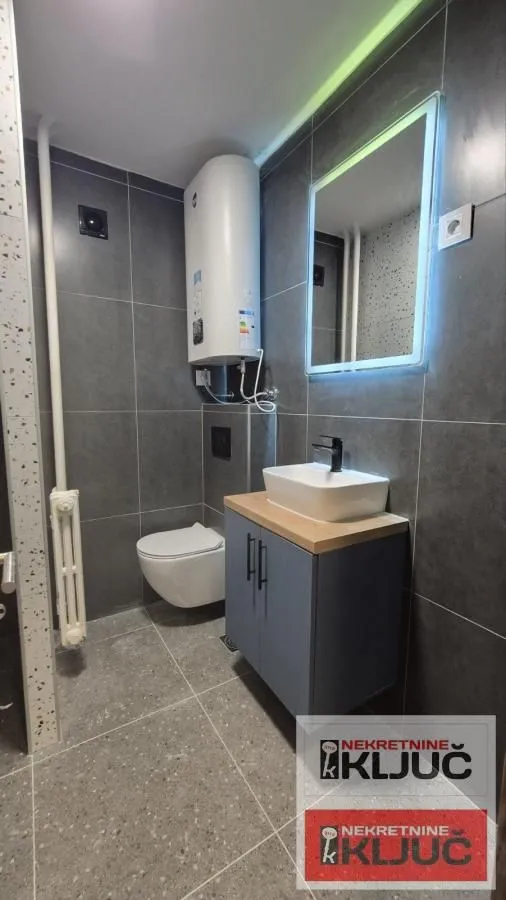 Moderno opremljeno kupatilo sa tuš kabinom, umivaonikom i bojlerom.