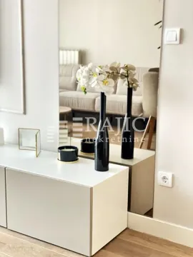 View of the living room with a mirror and decoration on the chest of drawers. - image 5