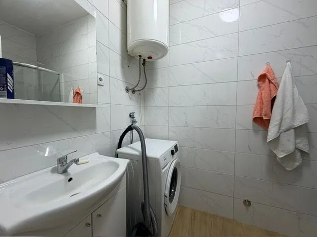 Manje kupatilo sa umivaonikom, veš mašinom i bojlerom.