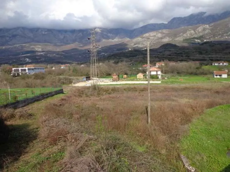 Pogled na zemljište sa prirodom i planinama u pozadini.