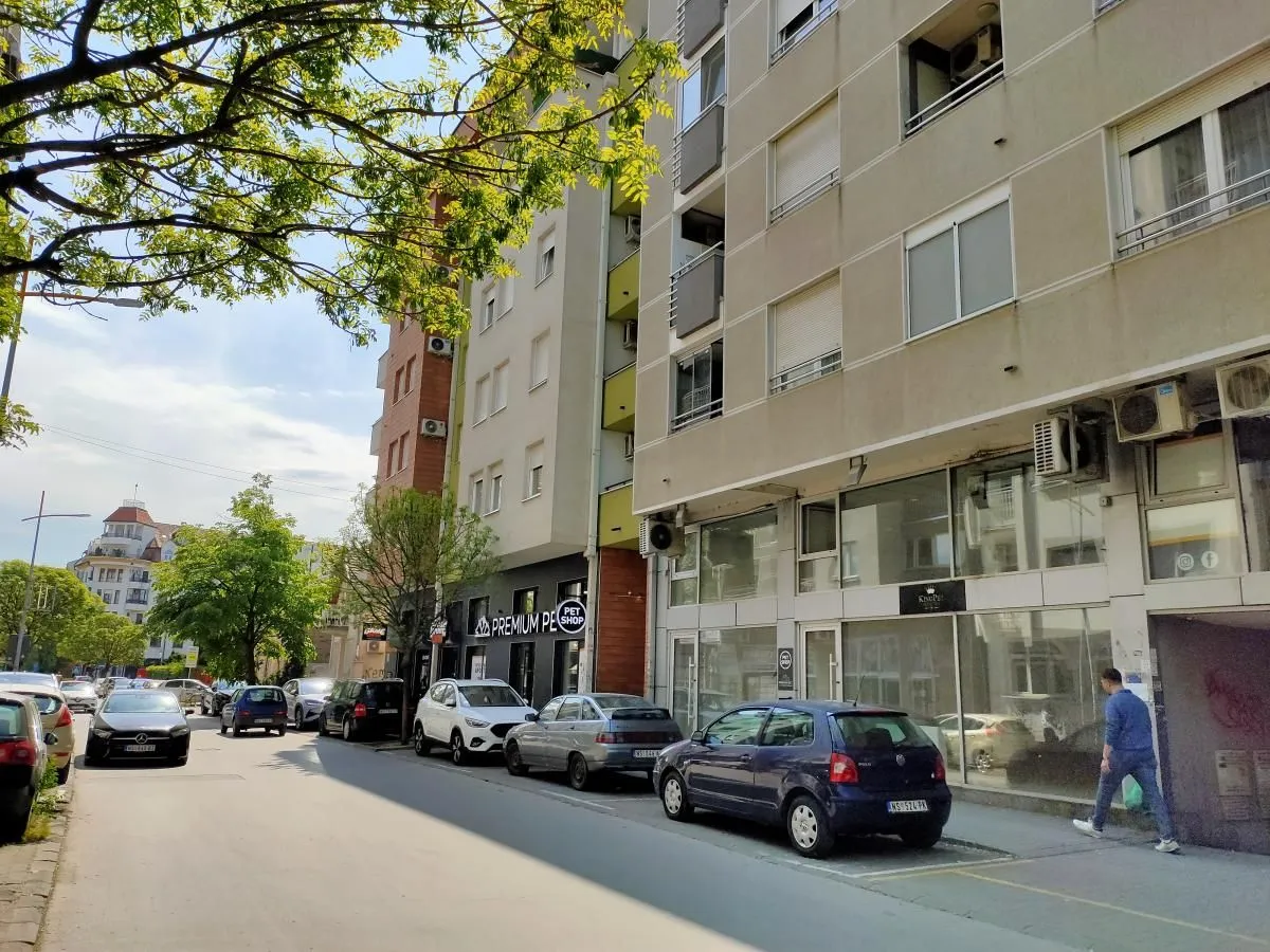 View of the street with parked cars in front of the residential building.